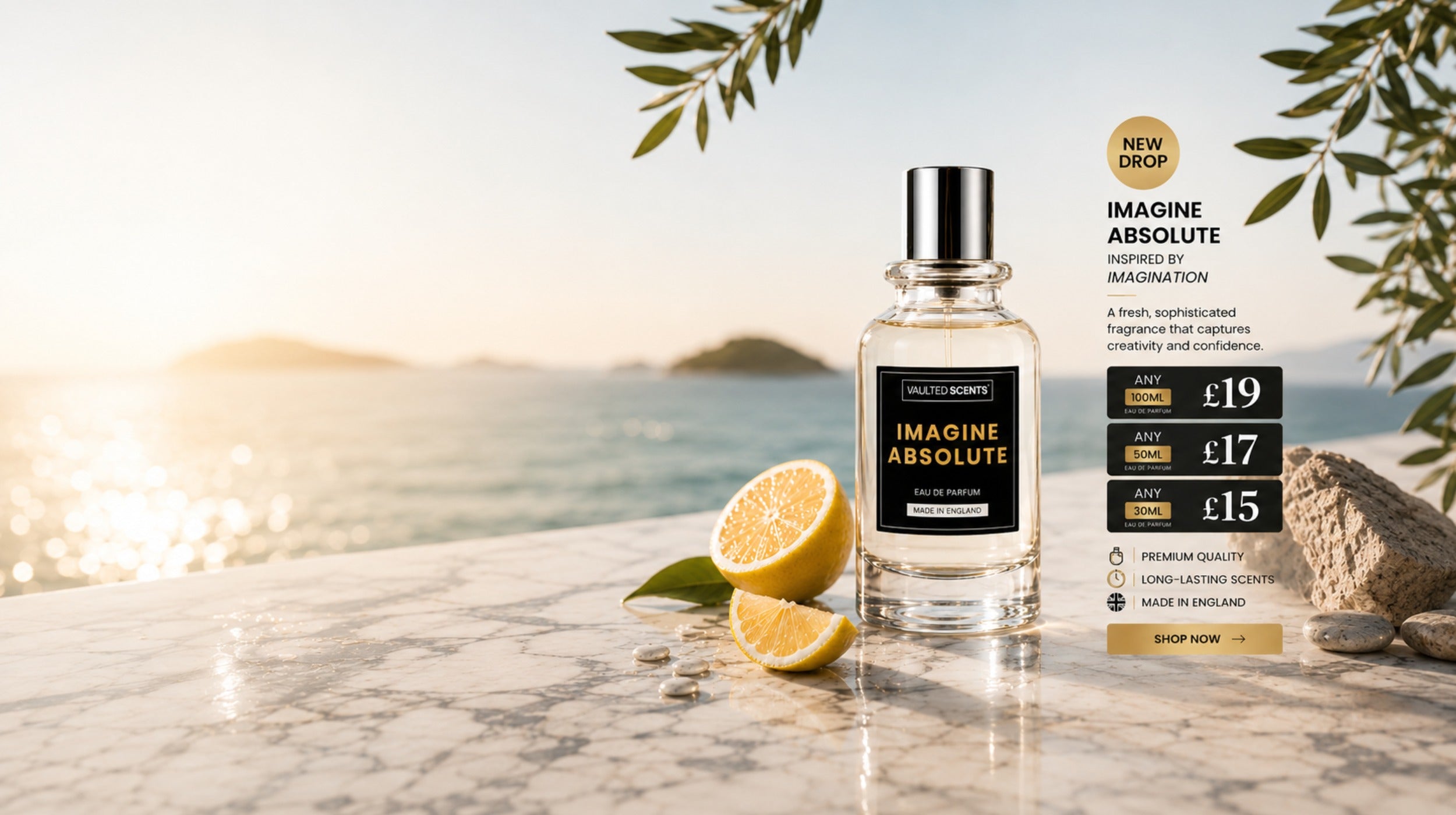 A bottle of Imagine Absolute fragrance by Pallant + Bennett stands on a marble surface outdoors by the sea at sunset, with lemon slices beside it and a promotional price card to the right.